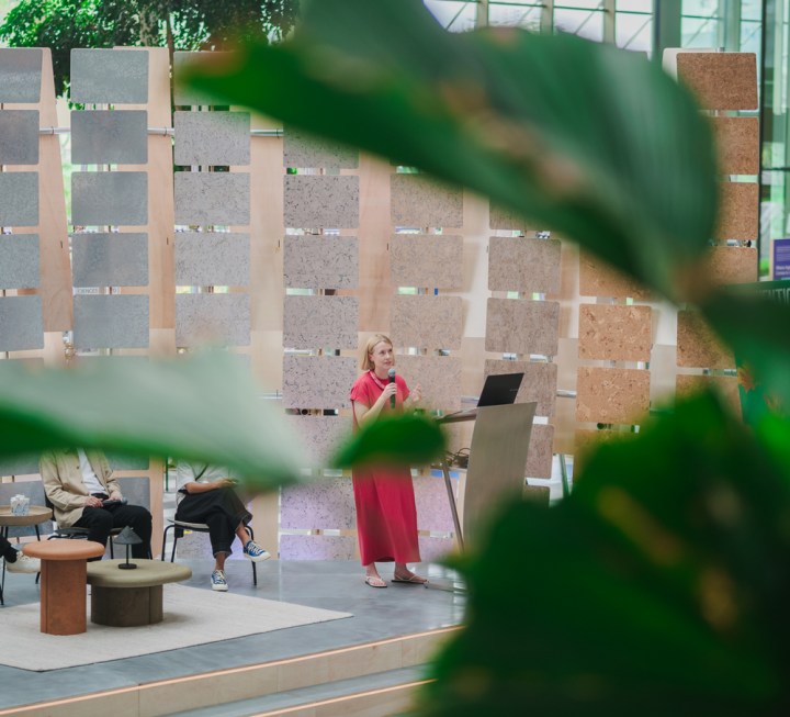 Nicola St John stands on a stage and presents at a podium.